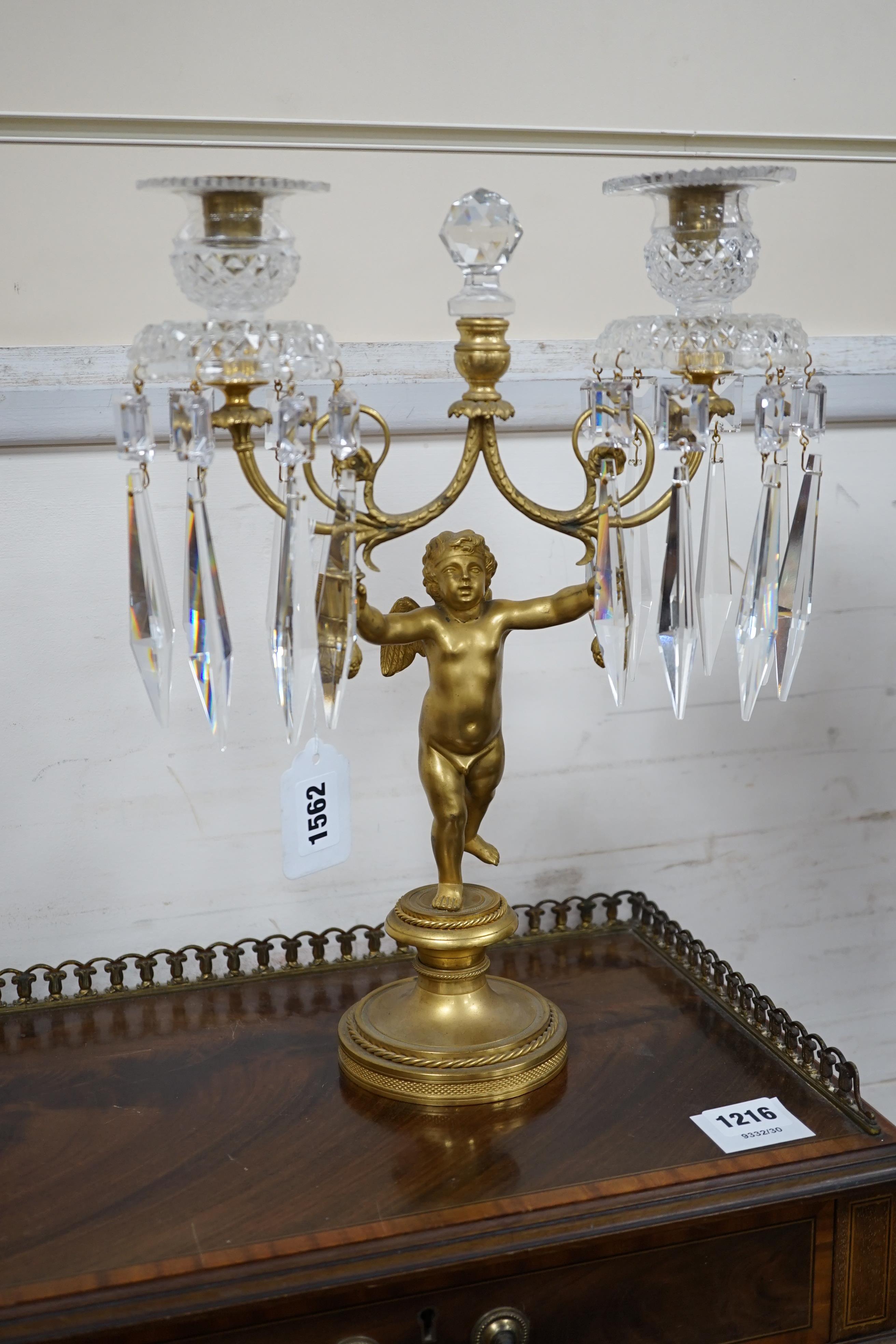 A pair of Regency ormolu ‘Cupid’ two branch glass lustre candelabra, 37cm high